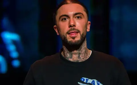 Malik Montana, z tatuażami na szyi, pokazuje język. Ile lat ma Malik Montana?